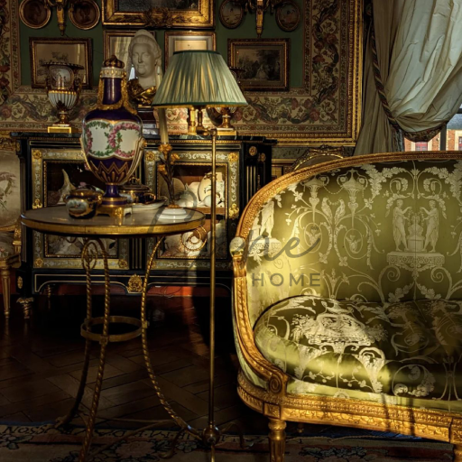 كنب باروك مذهب مغطى بحرير أخضر منقوش بجوار طاولة خدمة وفازة بورسلين ملكية.