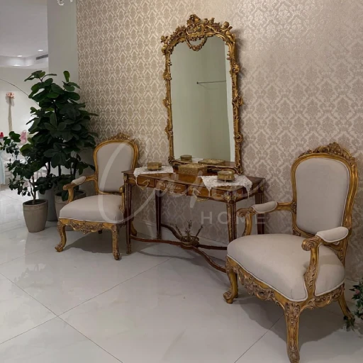 مدخل فرنسي خشب زان ملكي يضم كرسيين منجدين بقطيفة بيج وإطار مذهب (طقم فينيسيا) مع كونسول ومرآة ورق ذهب ضخمة.